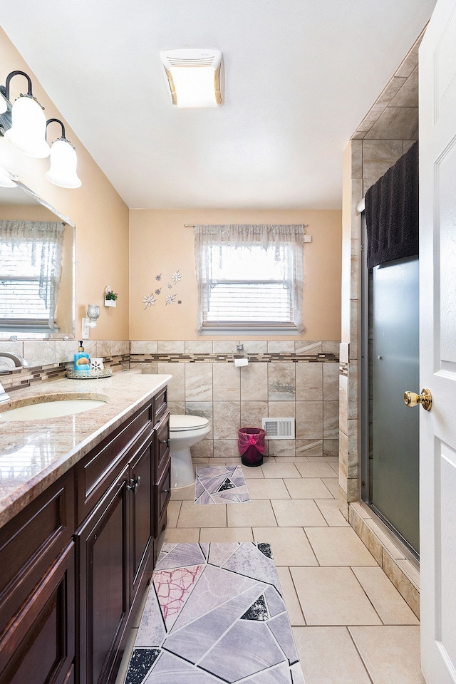 4810 Benjamin Dr, Sterling Heights, MI 48310 - bathroom with tile walls, tile patterned floors, a shower stall, vanity, and toilet