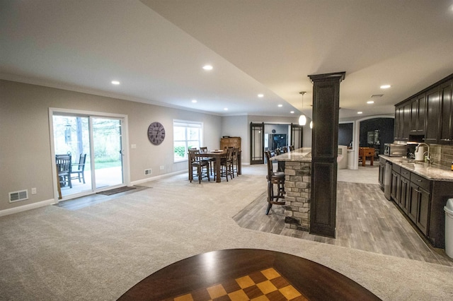 3817 Timber Green Ct, Howell, MI 48843 - kitchen featuring decorative columns, baseboards, light carpet, recessed lighting, and crown molding