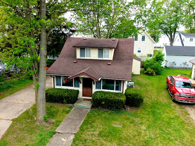 view of front of home featuring a shingled roof and a front lawn