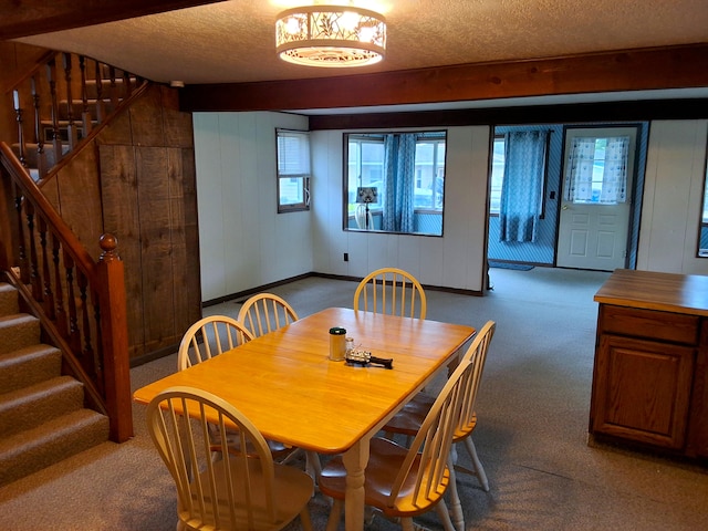 dining room featuring carpet floors, a textured ceiling, and stairs