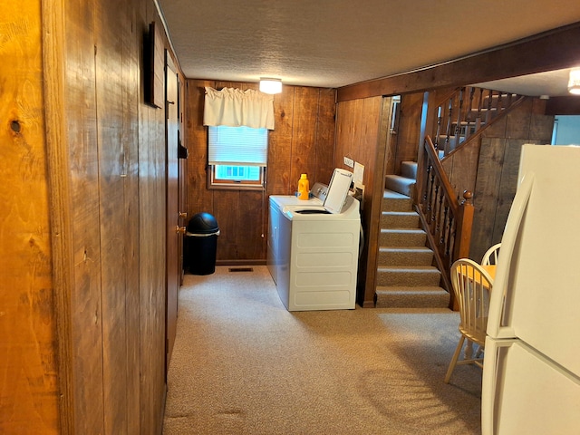 washroom with wooden walls, carpet, and a textured ceiling