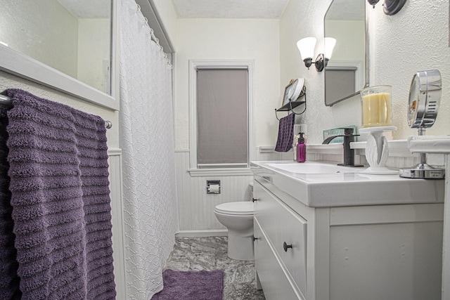 77 S Sprague St, Coldwater, MI 49036 - bathroom featuring a wainscoted wall, marble look tile flooring, toilet, vanity, and curtained shower