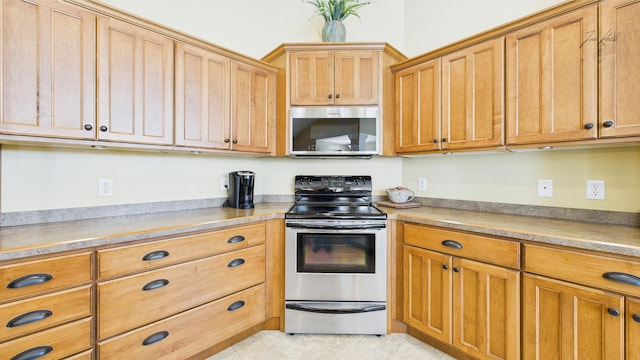 kitchen featuring appliances with stainless steel finishes, light tile patterned floors, and light countertops