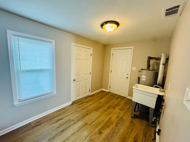 21974 Elroy Ave, Warren, MI 48089 - foyer entrance with wood finished floors, water heater, and baseboards