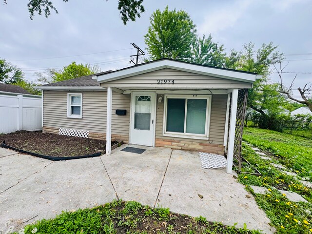 21974 Elroy Ave, Warren, MI 48089 - view of front facade with fence, a shingled roof, and a patio