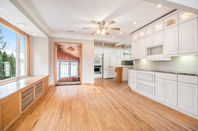 kitchen with white appliances, light wood-style flooring, glass insert cabinets, a ceiling fan, and white cabinetry