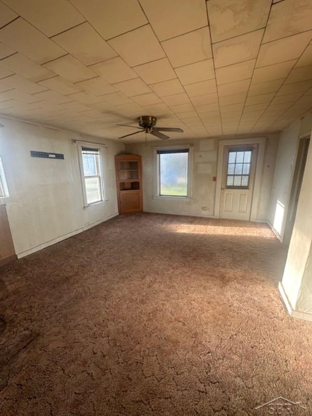 carpeted empty room featuring a ceiling fan