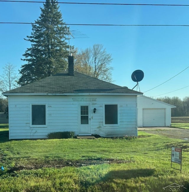 back of property with a chimney, a lawn, and dirt driveway