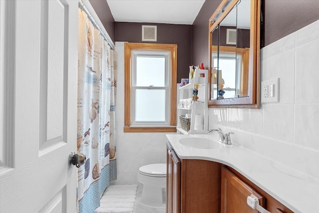full bath featuring tile walls, toilet, vanity, and a shower with curtain
