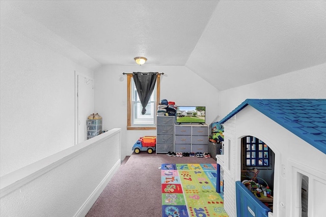 recreation room featuring carpet flooring, vaulted ceiling, and a textured ceiling