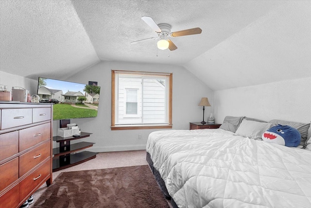bedroom featuring vaulted ceiling, a textured ceiling, carpet flooring, baseboards, and ceiling fan