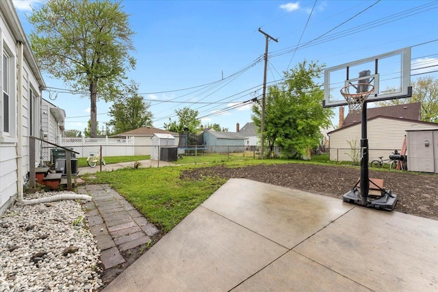 fenced backyard with a patio, a storage unit, central AC, and an outbuilding