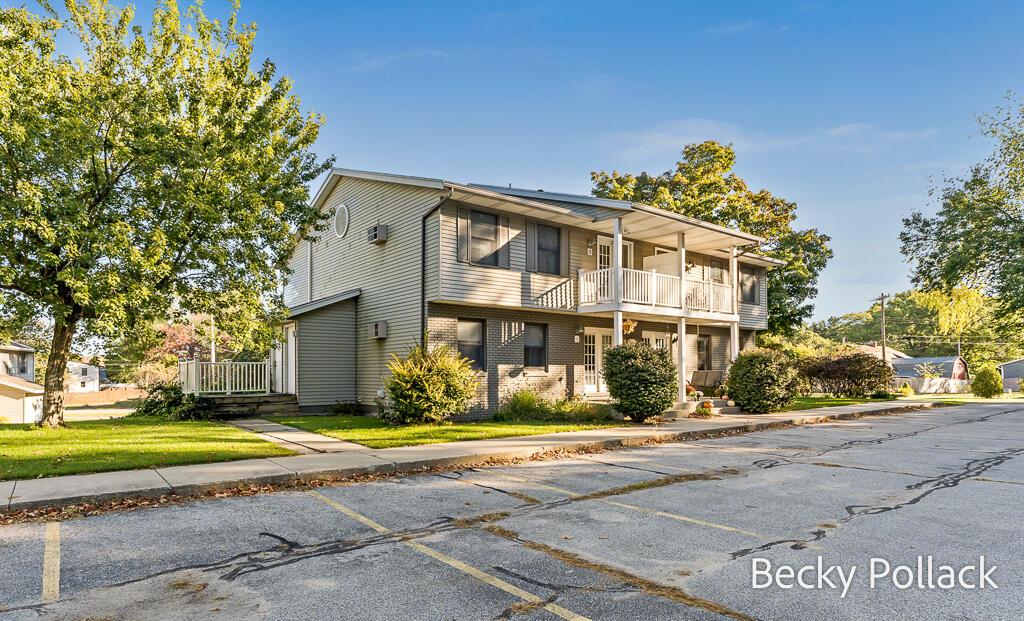 15278 Krueger St Unit 3, Spring Lake, MI 49456 - view of front of home with a balcony, a front yard, and uncovered parking