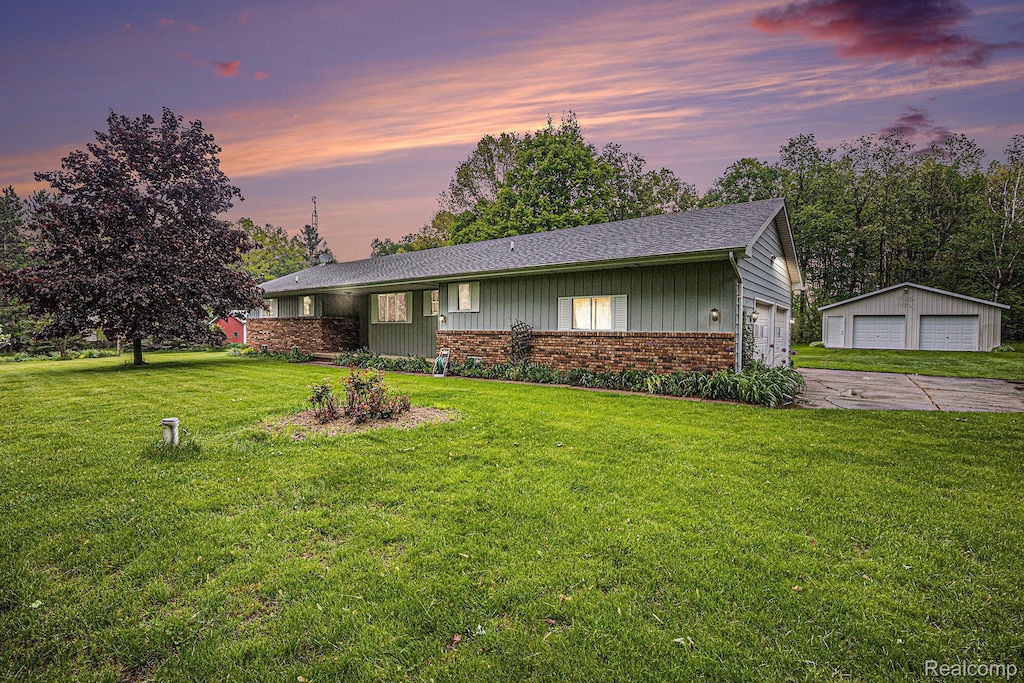 5120 Millis Rd, North Branch, MI 48461 - view of front of property featuring a garage, brick siding, a lawn, a shingled roof, and an outbuilding