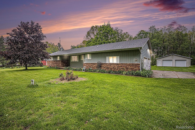 5120 Millis Rd, North Branch, MI 48461 - view of front of property featuring a garage, brick siding, a lawn, a shingled roof, and an outbuilding