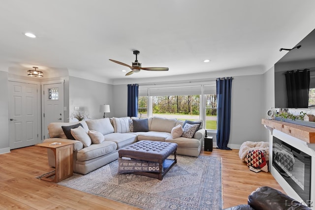 4730 Occidental Hwy, Adrian, MI 49221 - living area featuring ceiling fan, recessed lighting, a glass covered fireplace, wood finished floors, and baseboards