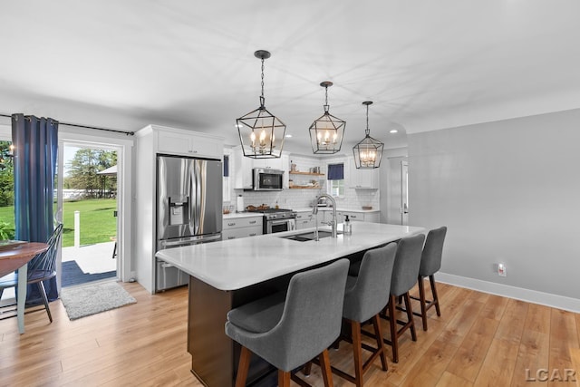 4730 Occidental Hwy, Adrian, MI 49221 - kitchen featuring appliances with stainless steel finishes, a sink, light countertops, a chandelier, and tasteful backsplash