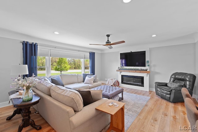 4730 Occidental Hwy, Adrian, MI 49221 - living area with a glass covered fireplace, light wood-type flooring, recessed lighting, a ceiling fan, and baseboards