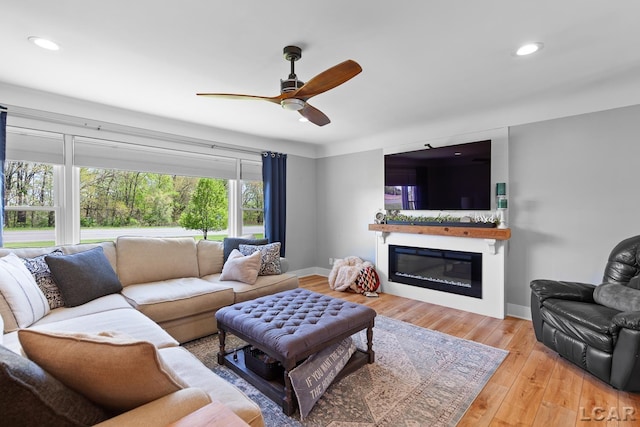 4730 Occidental Hwy, Adrian, MI 49221 - living room with ceiling fan, a glass covered fireplace, wood finished floors, baseboards, and recessed lighting