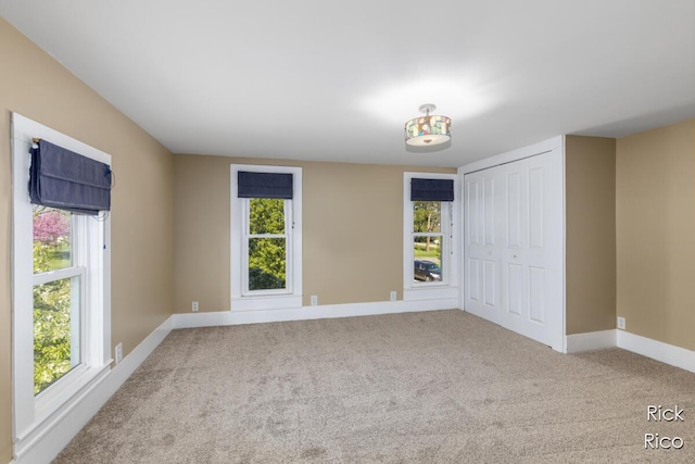 unfurnished bedroom featuring baseboards, carpet, and a closet