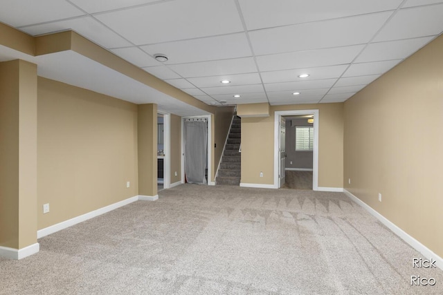 below grade area with stairway, carpet floors, recessed lighting, baseboards, and a drop ceiling