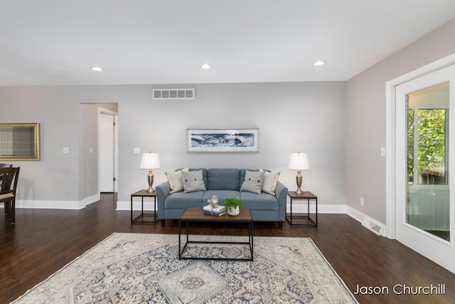 living room with wood finished floors, baseboards, and recessed lighting