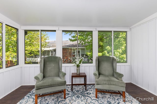 sunroom / solarium featuring wood finished floors, healthy amount of natural light, and a decorative wall