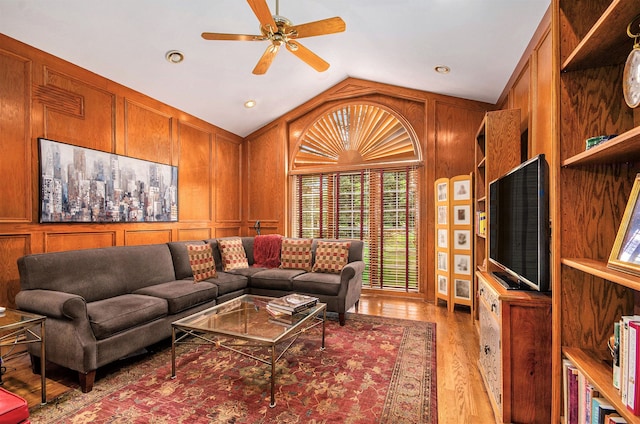 2200 Clearwood, Shelby Twp, MI 48316 - living area with light wood-style flooring, vaulted ceiling, ceiling fan, wood walls, and a decorative wall