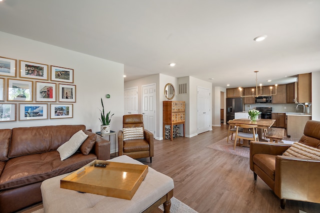 346 Quartz Way, White Lake, MI 48386 - living room with light wood-style flooring, baseboards, recessed lighting, and a chandelier