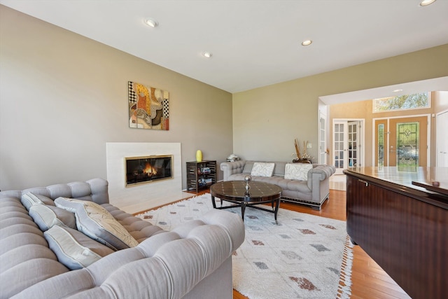 7039 Timberview Trl, West Bloomfield, MI 48322 - living area with light wood-type flooring, recessed lighting, a glass covered fireplace, and french doors