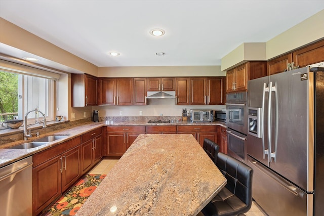 7039 Timberview Trl, West Bloomfield, MI 48322 - kitchen with appliances with stainless steel finishes, a sink, under cabinet range hood, a kitchen bar, and light stone counters