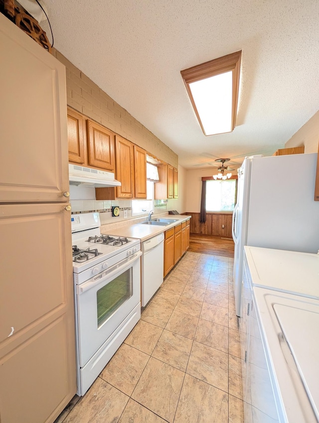 5062 Kendall Dr, Burton, MI 48509 - kitchen with white appliances, under cabinet range hood, light countertops, a sink, and a textured ceiling