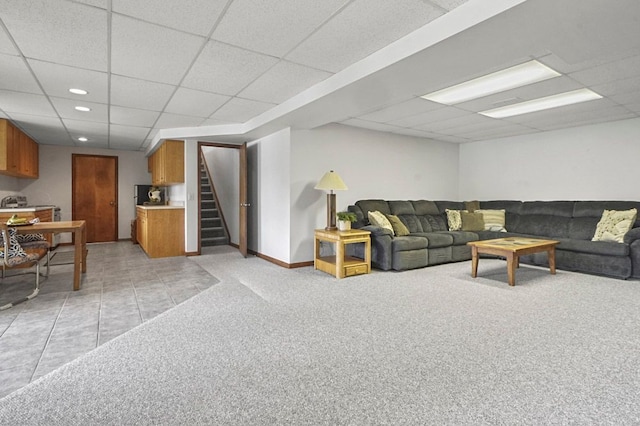 living room featuring a drop ceiling, stairs, recessed lighting, light colored carpet, and baseboards
