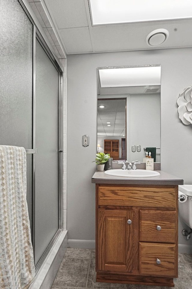 full bath featuring a stall shower, vanity, toilet, baseboards, and tile patterned flooring