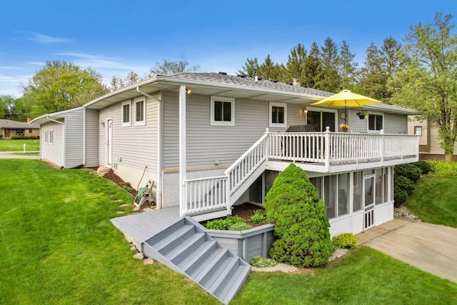 back of property featuring a deck and a lawn