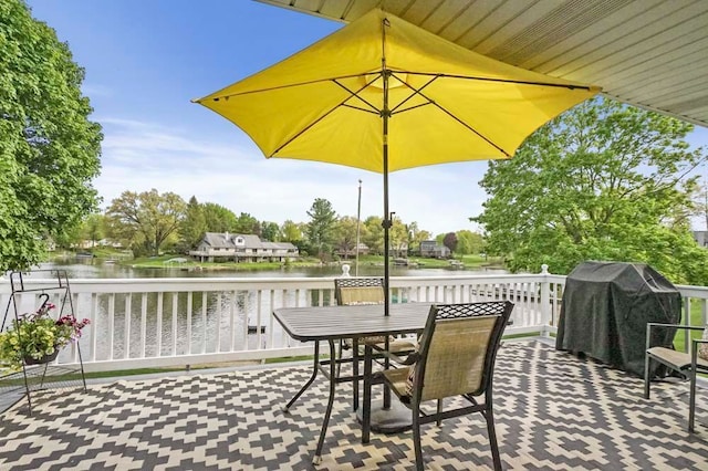 view of patio featuring a water view, grilling area, and outdoor dining space