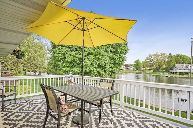 deck with a water view and outdoor dining area