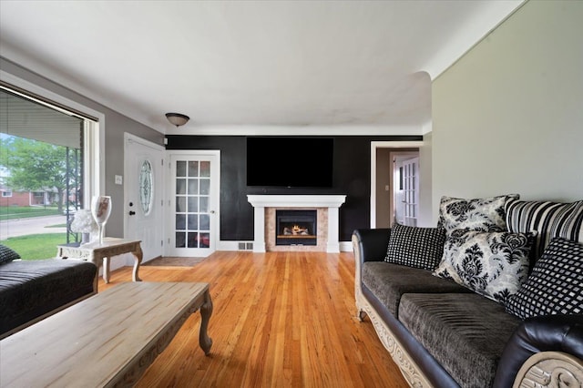 27607 Buckingham St, Livonia, MI 48154 - living room featuring a lit fireplace and light wood-style floors