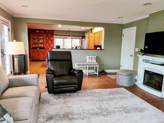 living room with light tile patterned flooring, ornamental molding, baseboards, recessed lighting, and a glass covered fireplace
