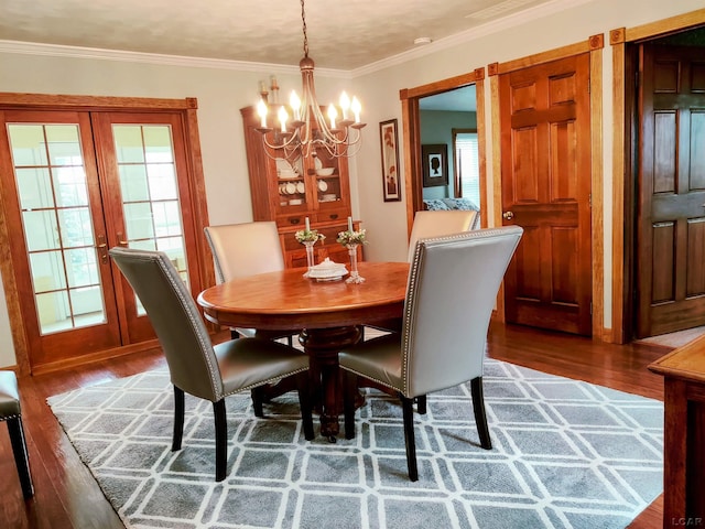 dining space with a chandelier, wood finished floors, and crown molding