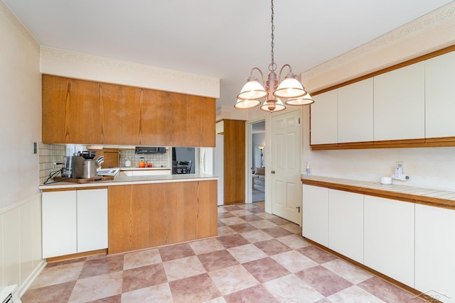 2303 Wilmington St, Midland, MI 48642 - kitchen with decorative backsplash, a chandelier, and white cabinetry