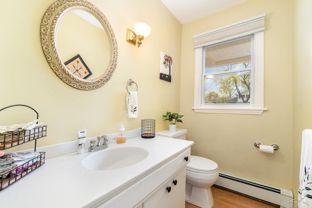 2303 Wilmington St, Midland, MI 48642 - bathroom with a baseboard heating unit, vanity, toilet, and wood finished floors
