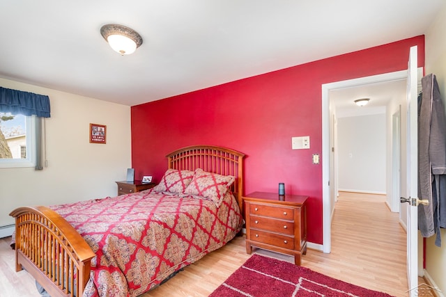 2303 Wilmington St, Midland, MI 48642 - bedroom with wood finished floors, baseboards, an accent wall, and a baseboard heating unit