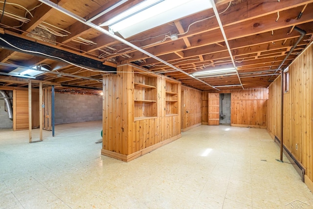 2303 Wilmington St, Midland, MI 48642 - unfinished below grade area with tile patterned floors, a baseboard heating unit, and wood walls