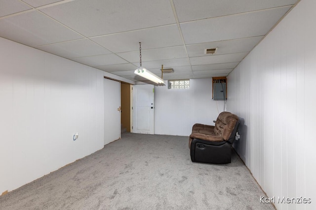 unfurnished room with carpet flooring, electric panel, and a paneled ceiling