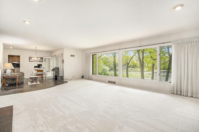 unfurnished living room with recessed lighting and a chandelier