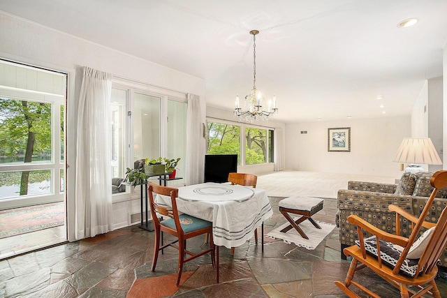 dining space featuring stone tile floors, a chandelier, and recessed lighting