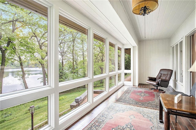 sunroom / solarium featuring wood finished floors, wooden ceiling, and wooden walls