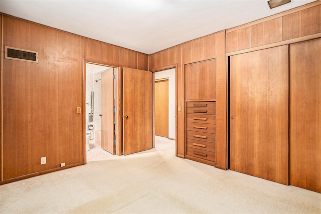 unfurnished bedroom featuring carpet floors, a closet, and ensuite bathroom