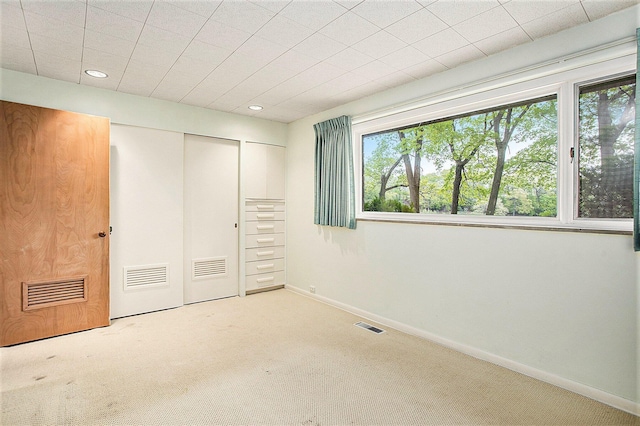 unfurnished bedroom featuring carpet floors, a closet, recessed lighting, and baseboards